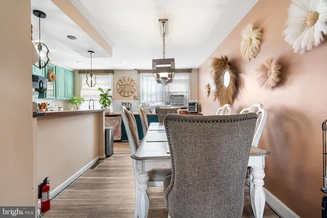 a dining room with furniture a chandelier and wooden floor