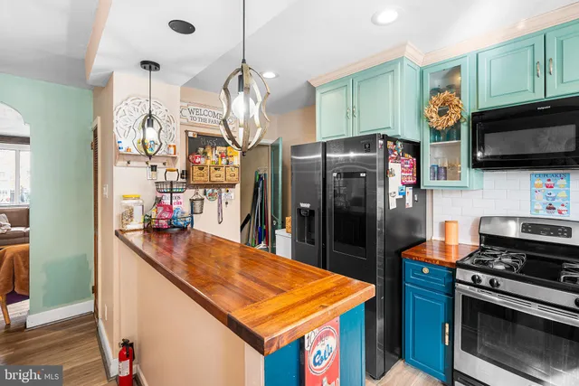 a kitchen with stainless steel appliances granite countertop a refrigerator a stove and a sink