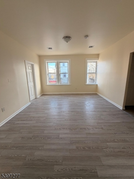 120 Bragaw Avenue, Unit 3 Newark, NJ 07112 - Photo 7 of 16 an empty room with wooden floor and windows
