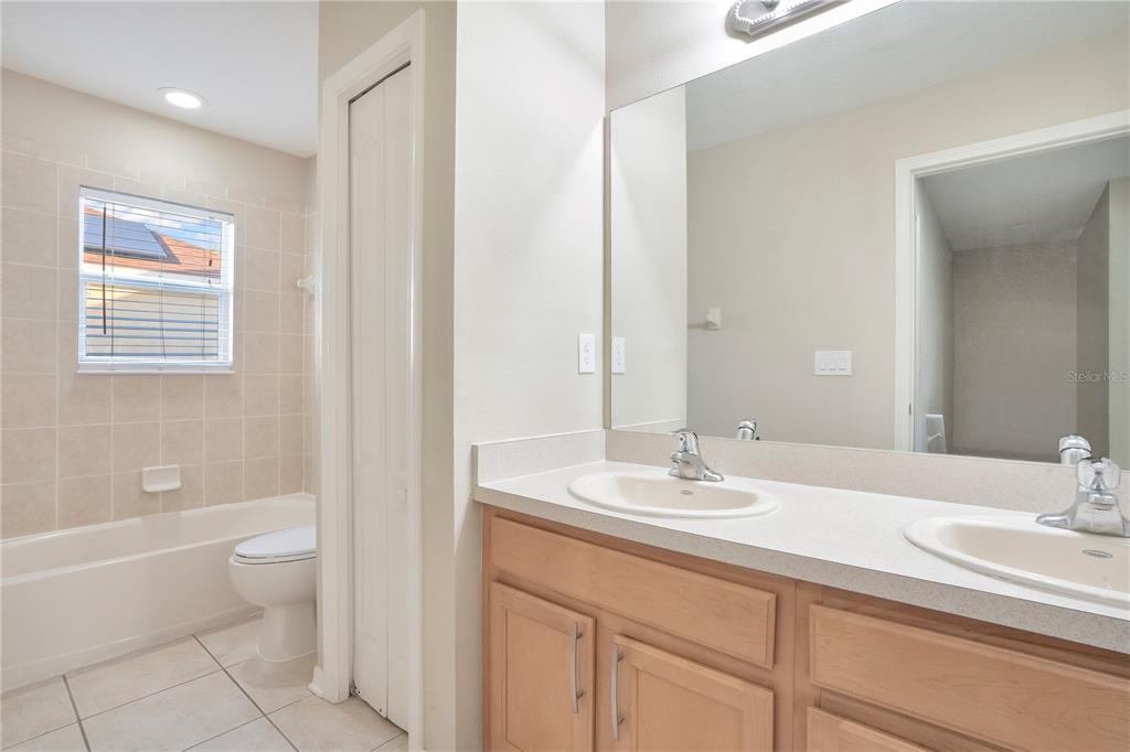 15031 Skip Jack Loop Lakewood Ranch, FL 34202 - Photo 21 of 27 a bathroom with a sink a toilet and a large mirror