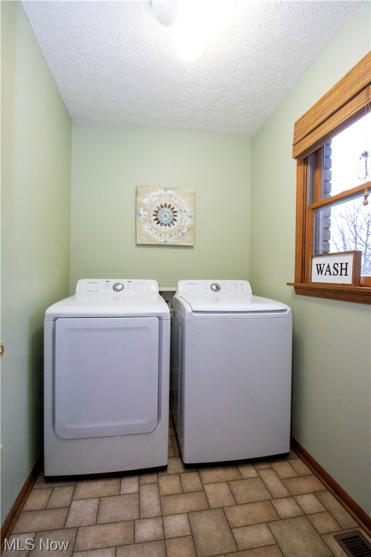 8084 Millbrook Road Shreve, OH 44676 - Photo 9 of 35 Laundry room with a textured ceiling and washing machine and dryer