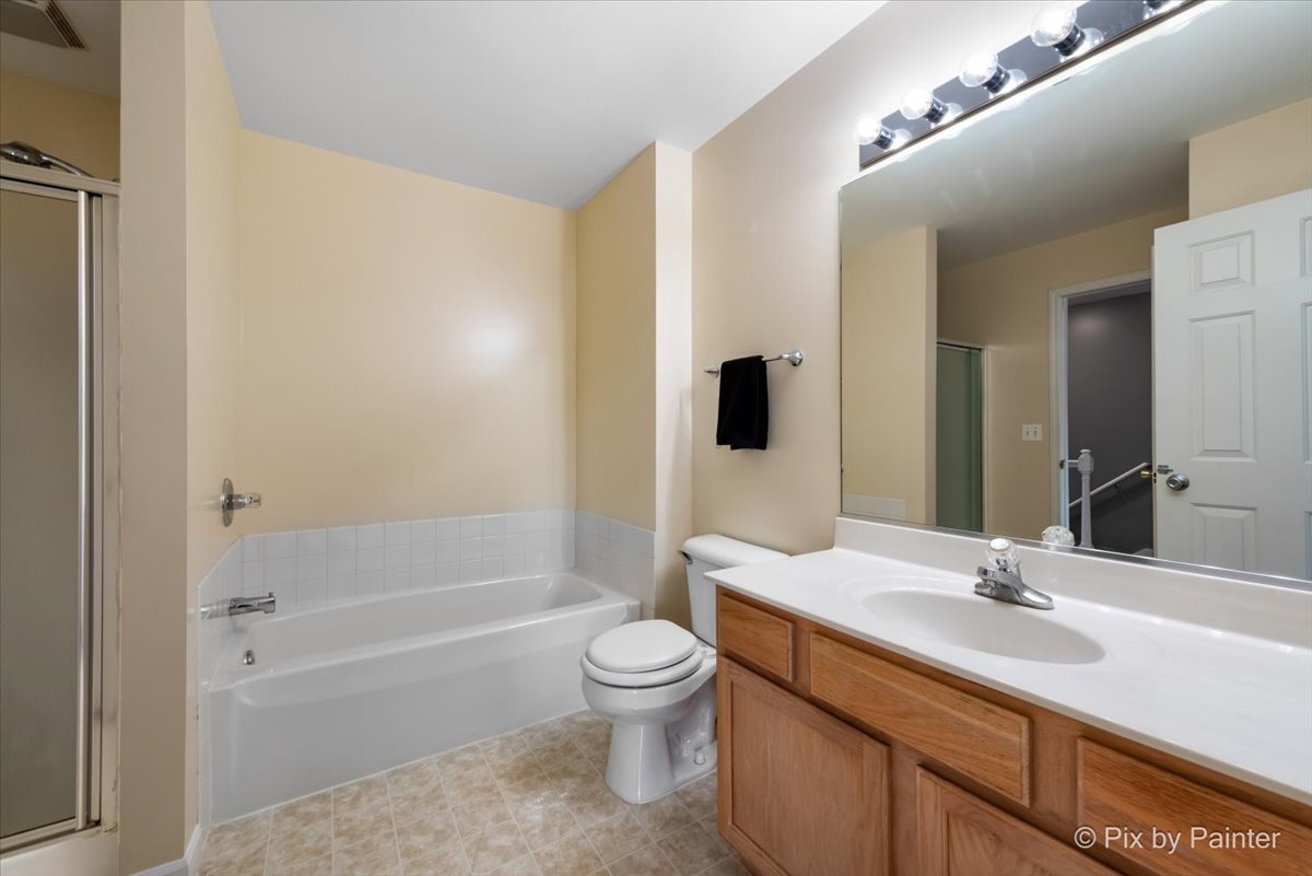 5742 Fieldstone Trail McHenry, IL 60050 - Photo 20 of 29 a bathroom with a sink a toilet and a large mirror