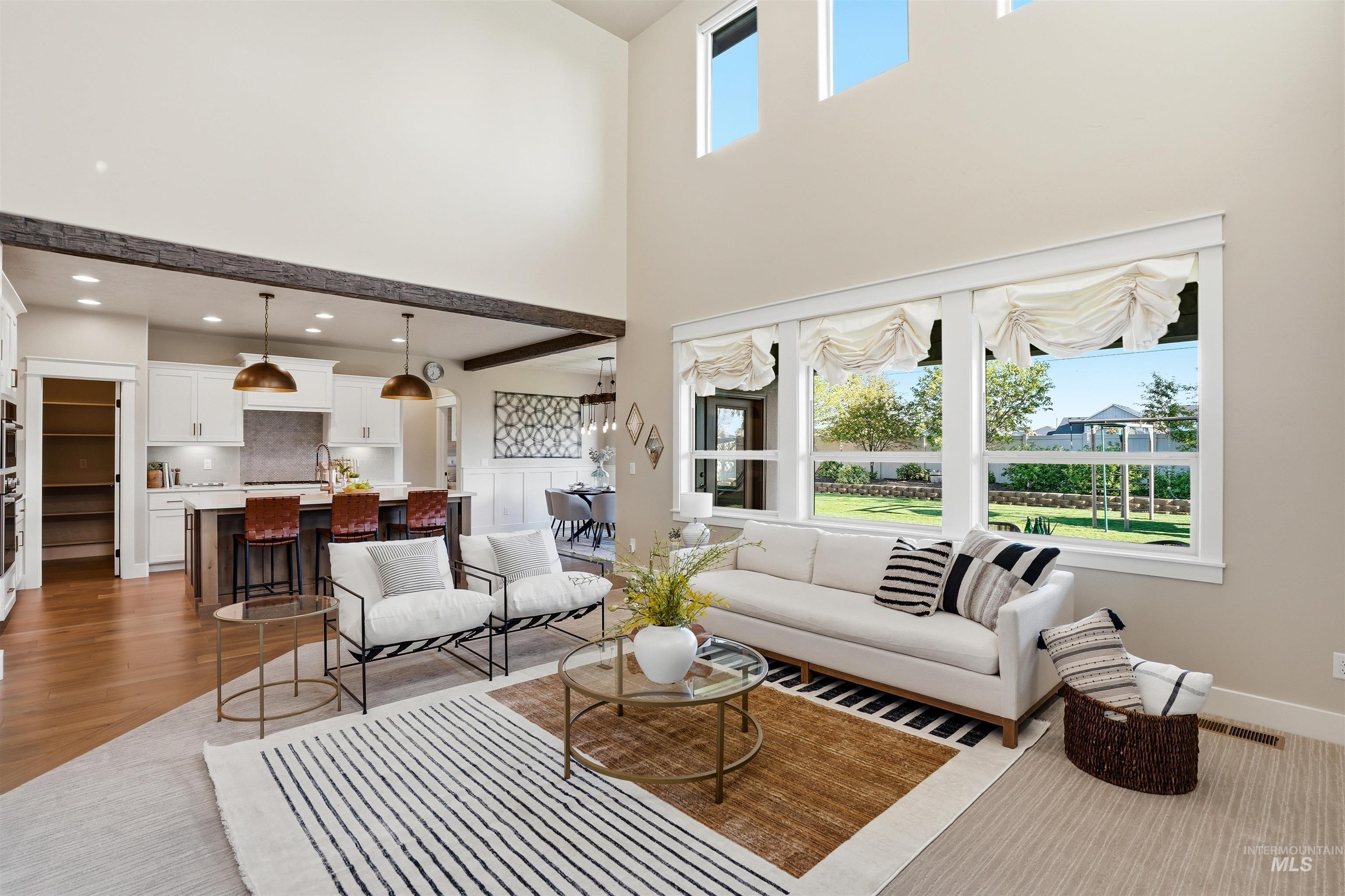 3915 West Riva Capri Street Meridian, ID 83646 - Photo 13 of 49 Open-concept living area featuring high ceilings, hardwood-style flooring, and large windows
