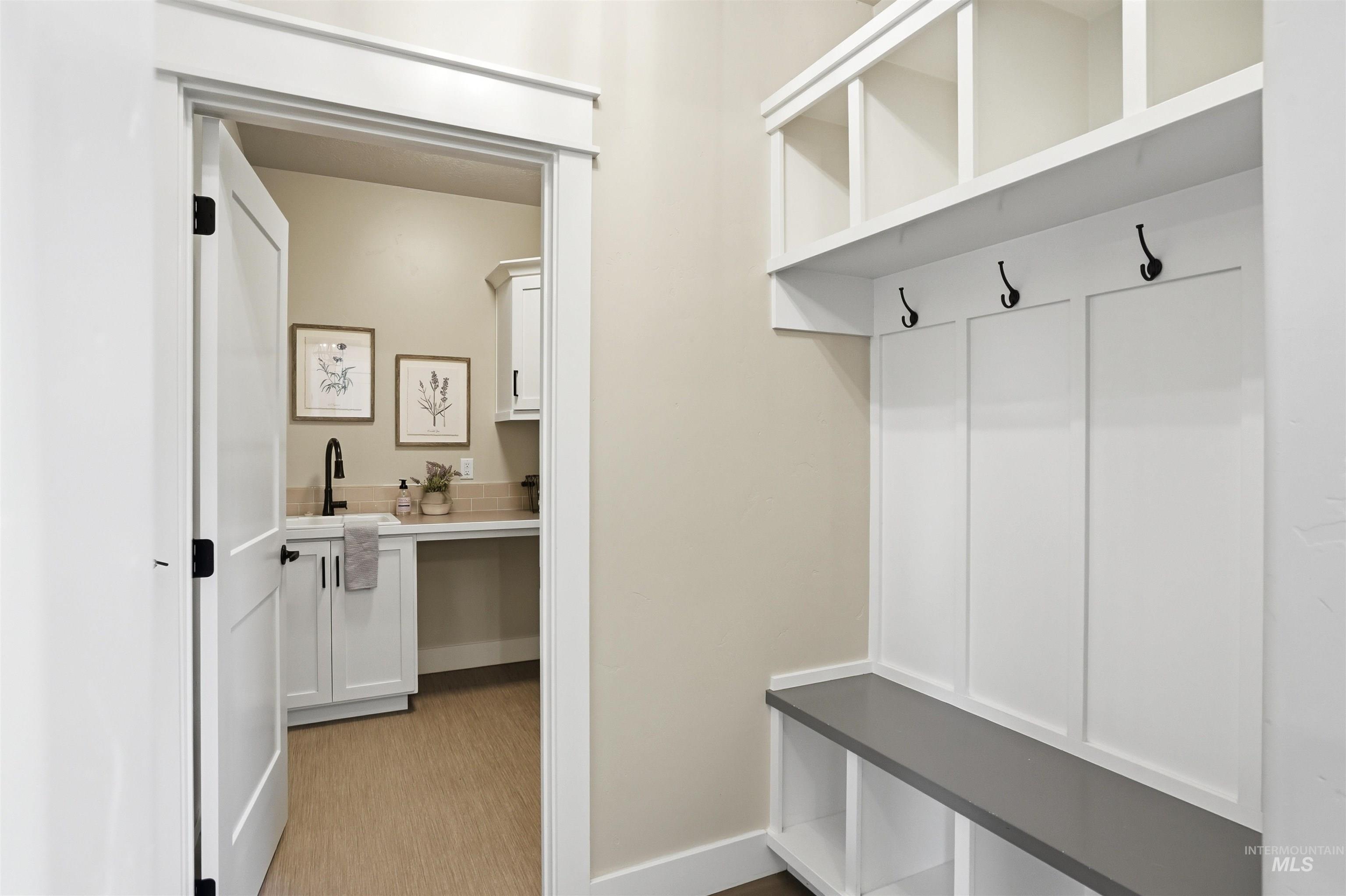 3915 West Riva Capri Street Meridian, ID 83646 - Photo 17 of 49 Built-in mudroom bench with storage cubbies, three coat hooks, and upper open shelving