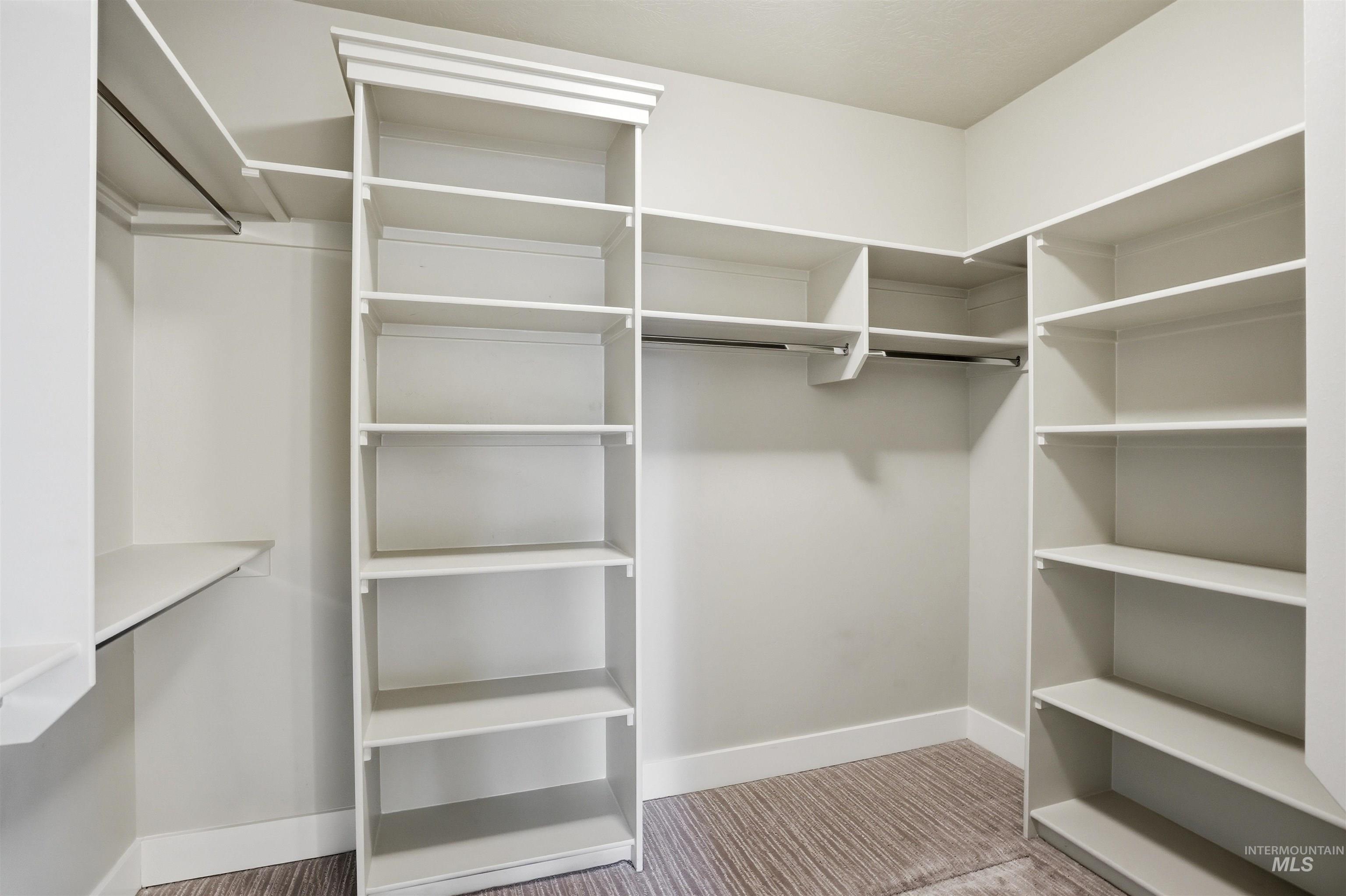 3915 West Riva Capri Street Meridian, ID 83646 - Photo 23 of 49 Walk-in closet featuring built-in shelving, hanging rods, an integrated corner unit, and textured carpet flooring
