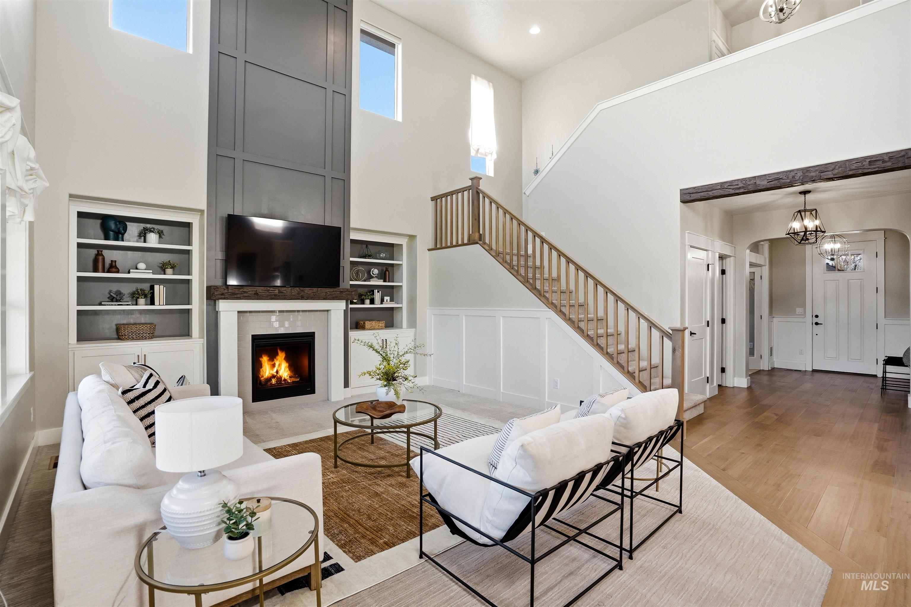 3915 West Riva Capri Street Meridian, ID 83646 - Photo 24 of 49 Two-story living room featuring a floor-to-ceiling accent wall with a fireplace and built-in shelving