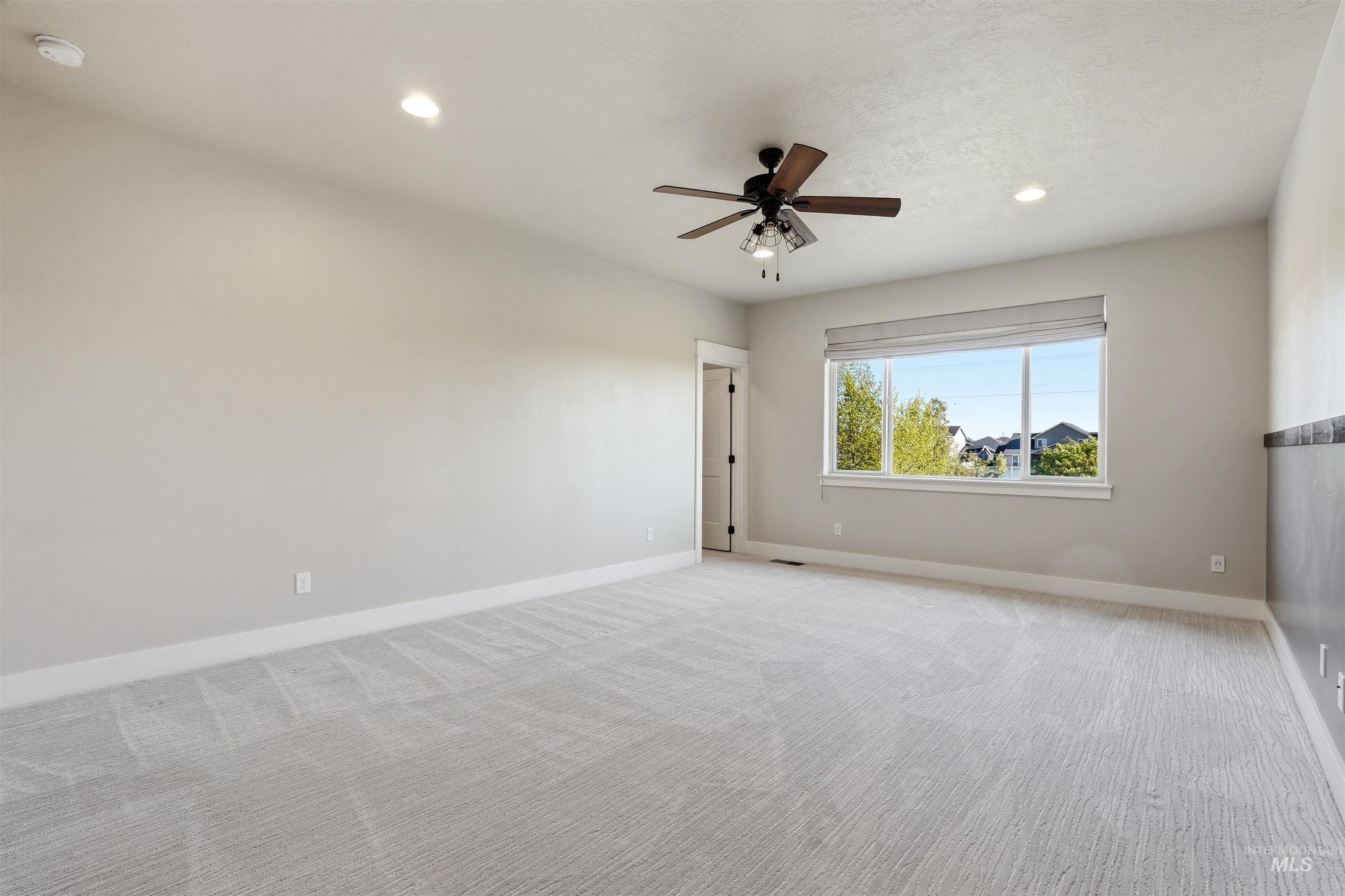3915 West Riva Capri Street Meridian, ID 83646 - Photo 28 of 49 Spacious room featuring light-toned carpeting, recessed ceiling lighting, and a dark wood-finish ceiling fan