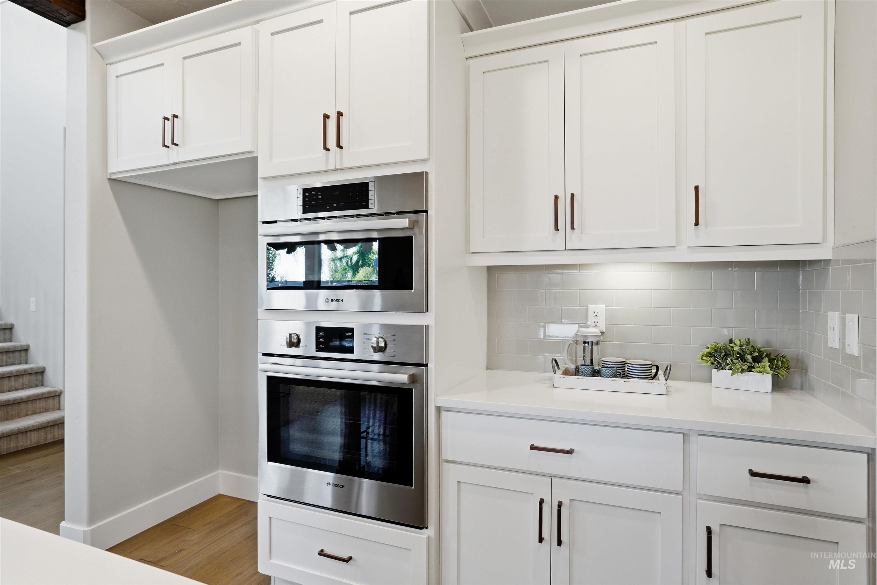 3915 West Riva Capri Street Meridian, ID 83646 - Photo 8 of 49 White shaker cabinetry with dark hardware and built-in stainless steel appliances