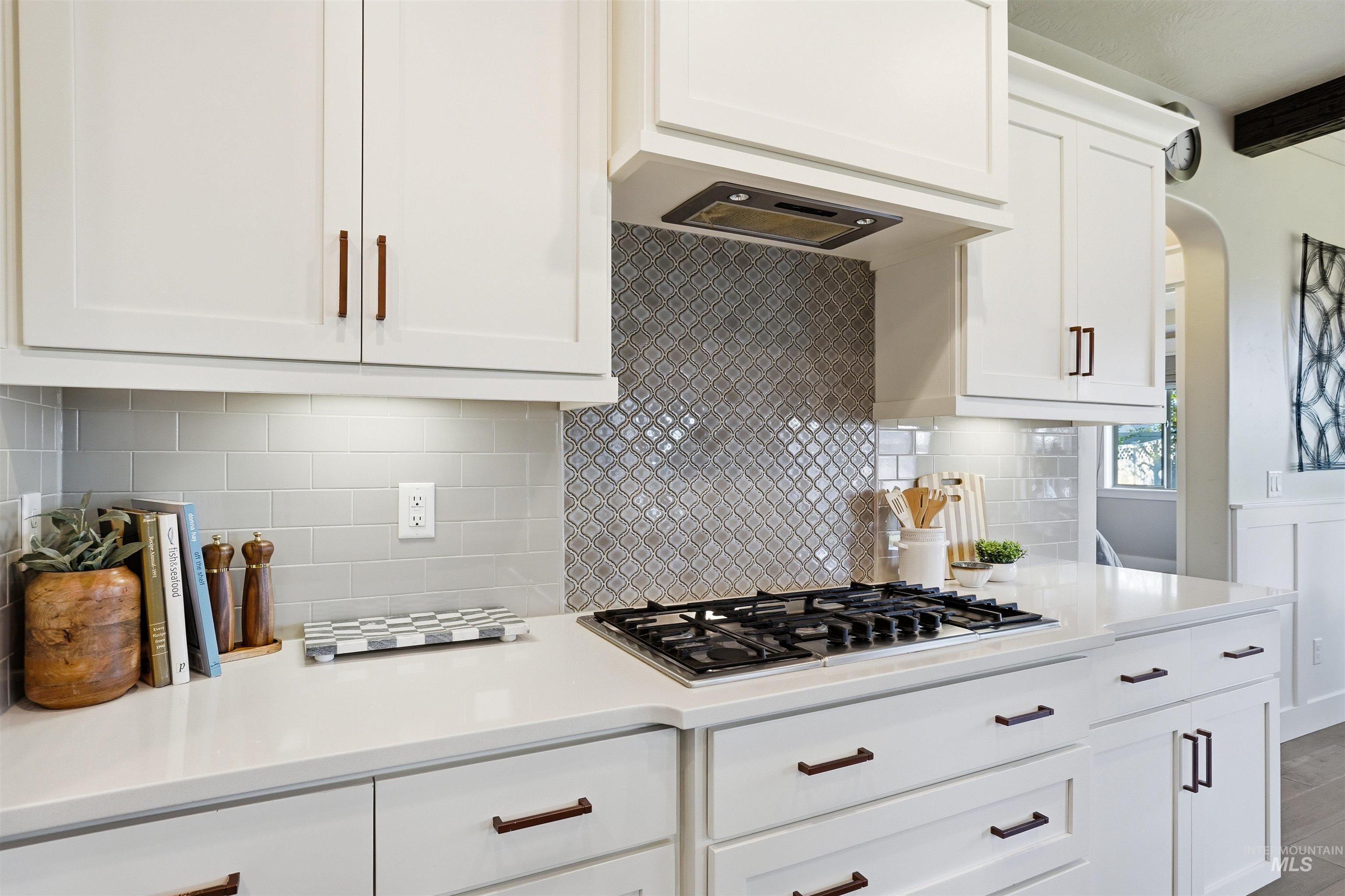 3915 West Riva Capri Street Meridian, ID 83646 - Photo 9 of 49 Kitchen featuring white shaker-style cabinetry, a built-in gas cooktop, and a decorative tile backsplash