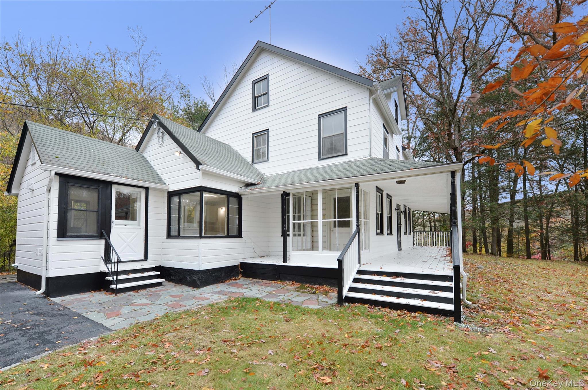 19 Johnsontown Road Sloatsburg, NY 10974 - Photo 15 of 41 a white house that has a wooden bench next to a road