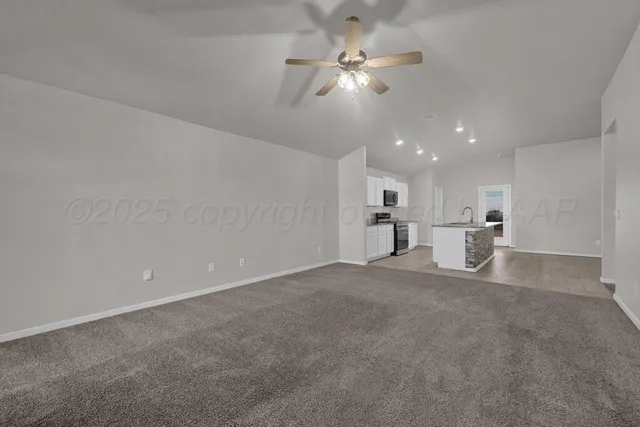 a view of a big room with windows and chandelier fan