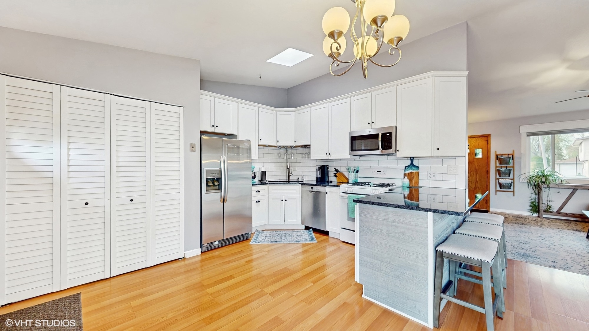 2206 Oak Lane Rolling Meadows, IL 60008 - Photo 6 of 24 a kitchen with stainless steel appliances granite countertop a refrigerator a stove a sink dishwasher a dining table and chairs with wooden floor