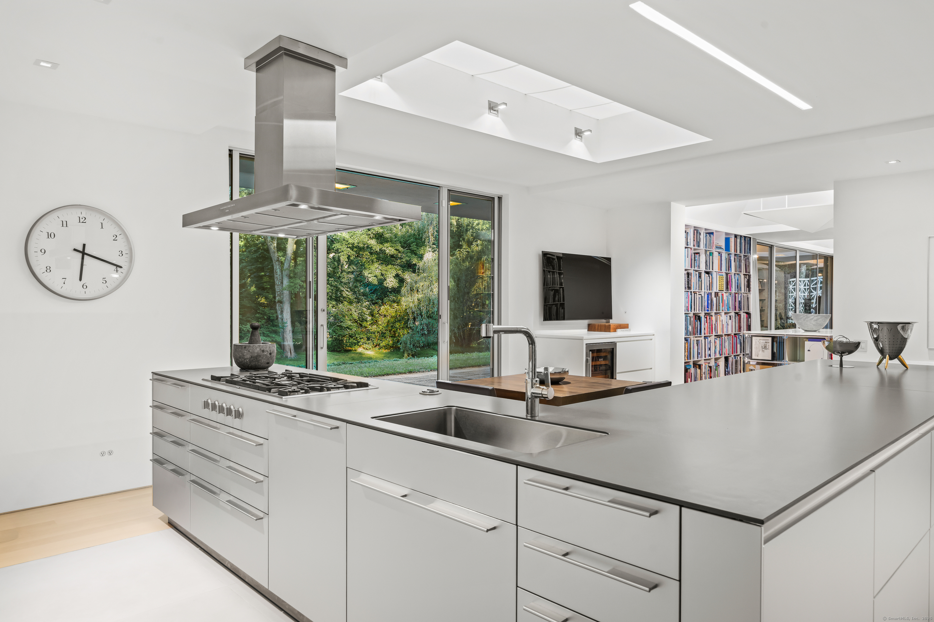565 Oenoke Ridge New Canaan, CT 06840 - Photo 15 of 39 a kitchen with sink stove and white cabinets with wooden floor