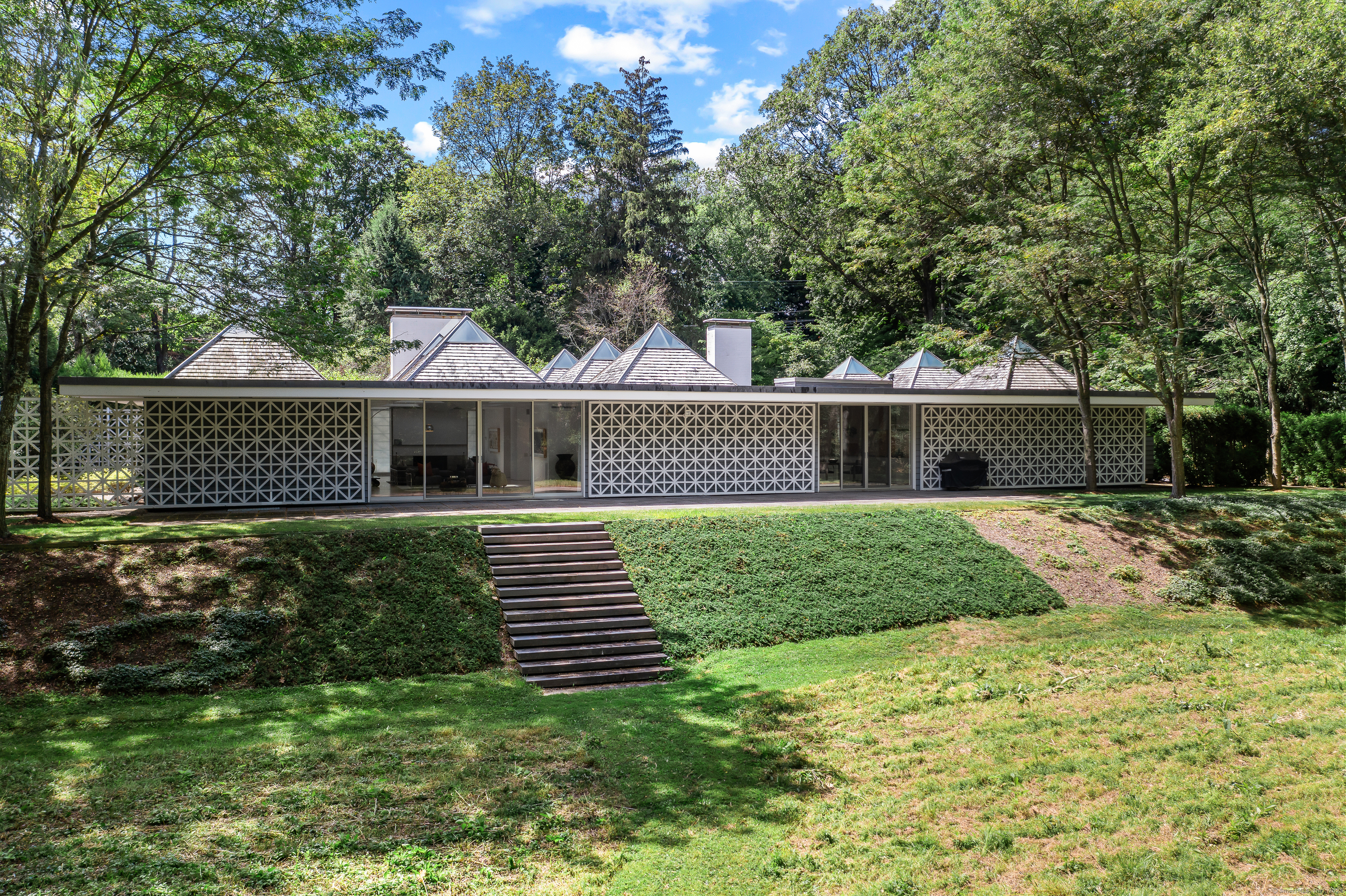 565 Oenoke Ridge New Canaan, CT 06840 - Photo 29 of 39 a front view of a house with a yard