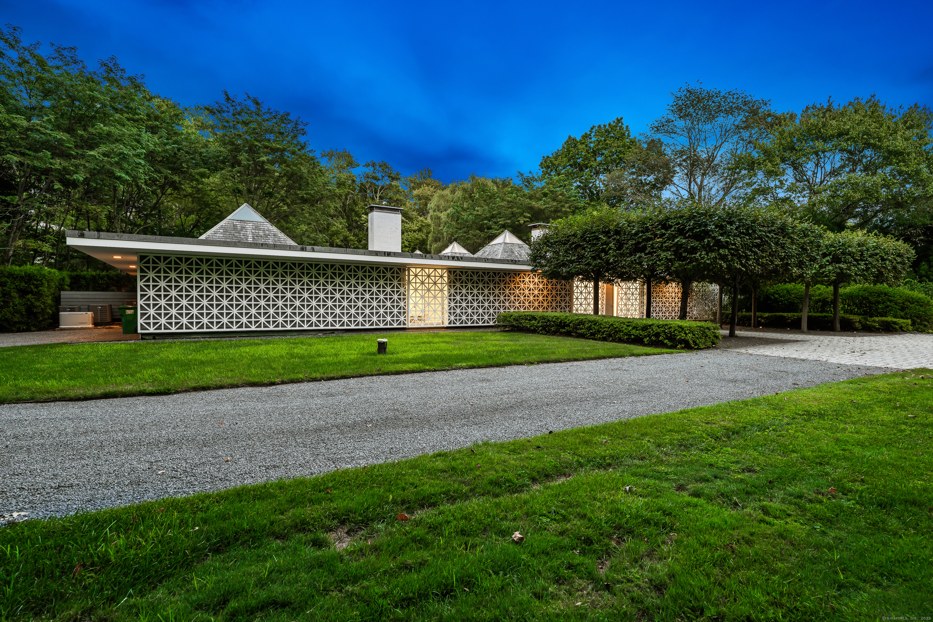 565 Oenoke Ridge New Canaan, CT 06840 - Photo 32 of 39 a front view of a house with a garden