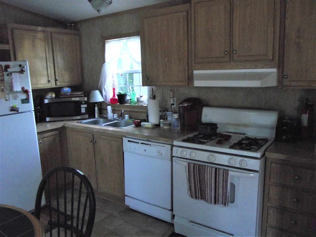 51 Monson Turnpike Road, Unit 1054 Ware, MA 01082 - Photo 11 of 23 a kitchen with a stove a sink and a microwave