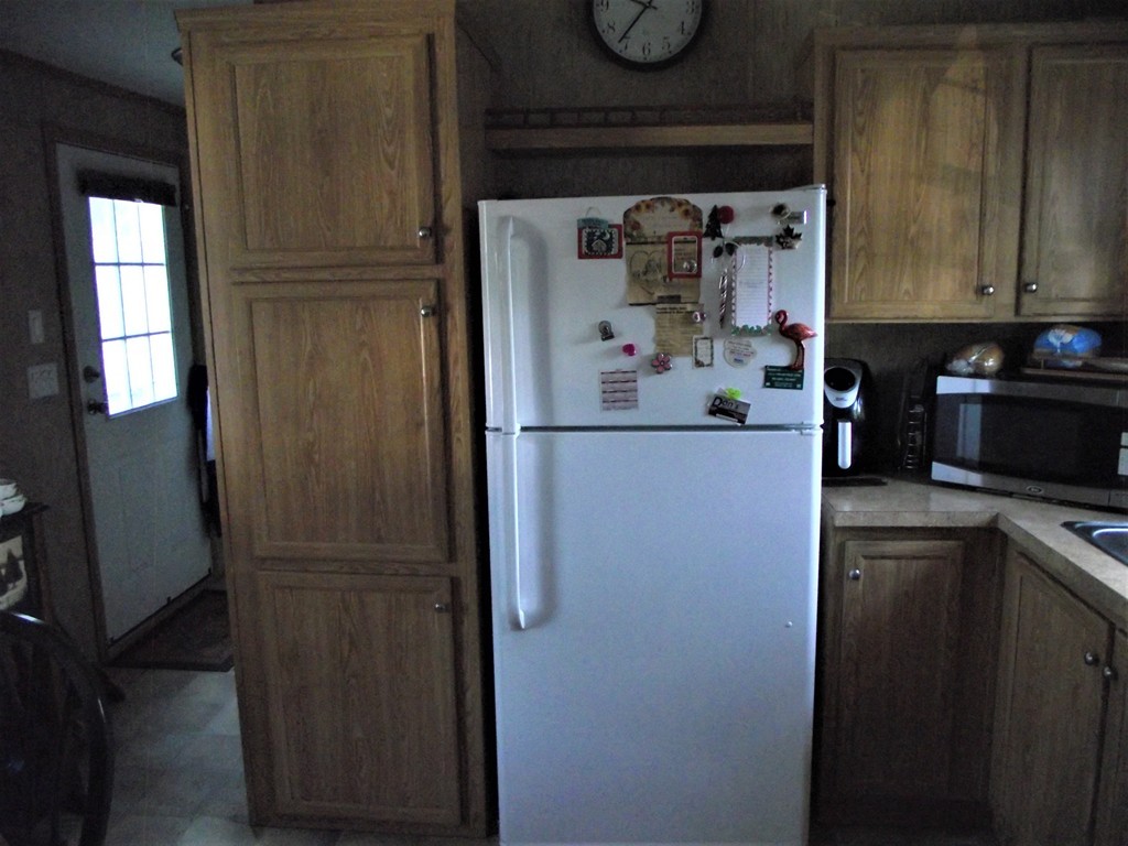 51 Monson Turnpike Road, Unit 1054 Ware, MA 01082 - Photo 14 of 23 a kitchen with a refrigerator and cabinets