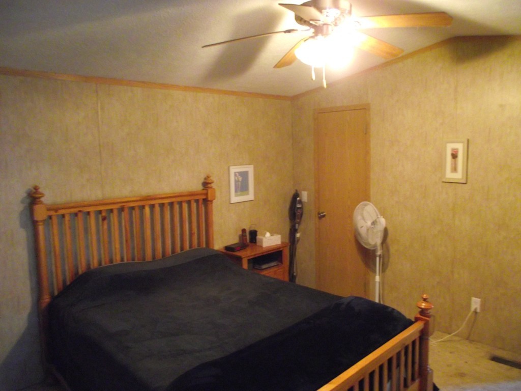 51 Monson Turnpike Road, Unit 1054 Ware, MA 01082 - Photo 4 of 23 a bedroom with a bed and wooden floor