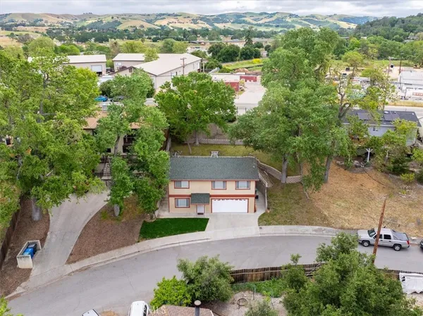 an aerial view of residential houses with outdoor space and trees