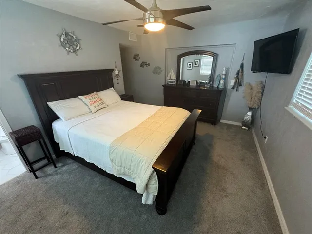 a bed sitting in a bedroom and tv on dresser