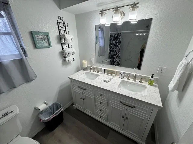 a bathroom with a sink vanity mirror and toilet