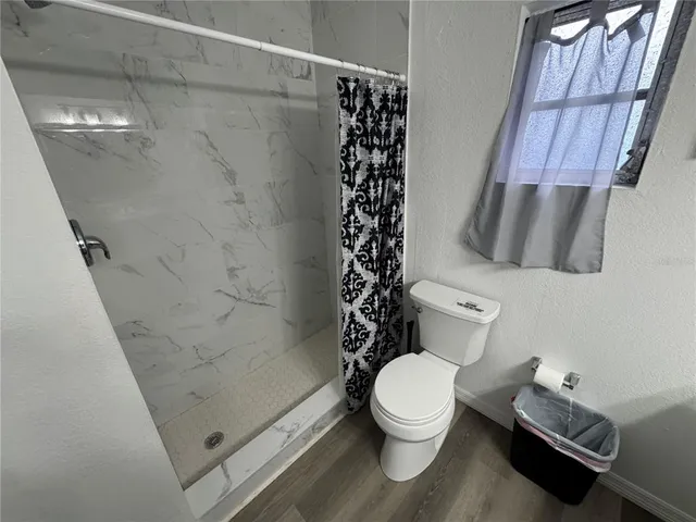 a bathroom with a toilet and a shower