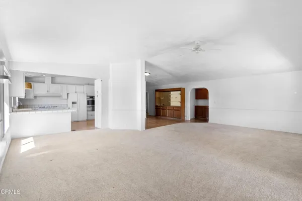 a view of an empty room with a kitchen