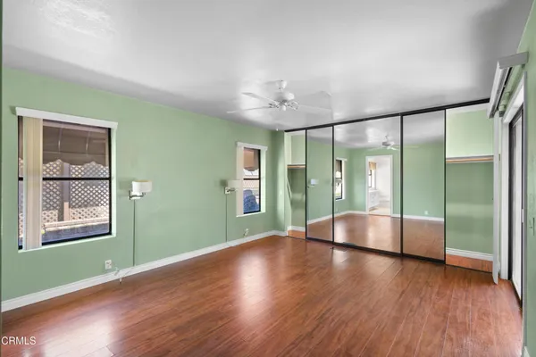 a view of an empty room with window and wooden floor