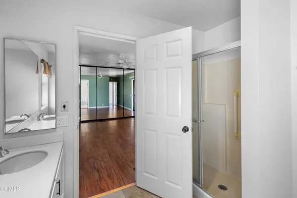 a en suite bathroom with a granite countertop sink and a mirror