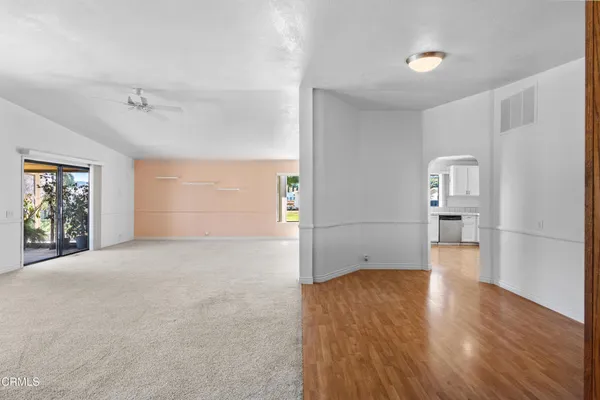 a view of empty room with wooden floor and window