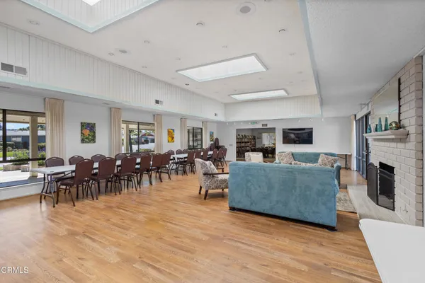 a living room with furniture a fireplace and a dining table with wooden floor