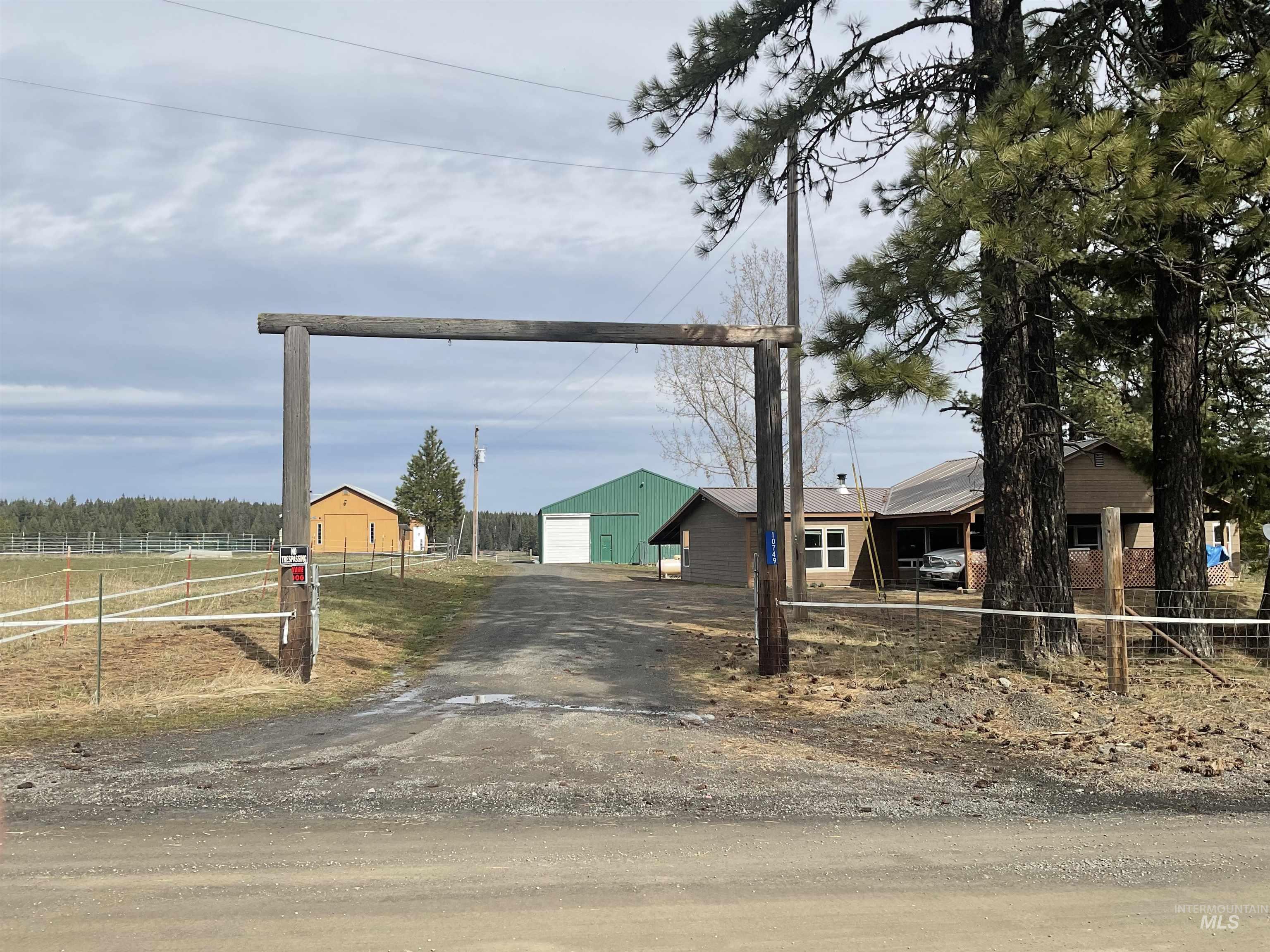 View of front of house with driveway, a detached garage, and an outdoor structure