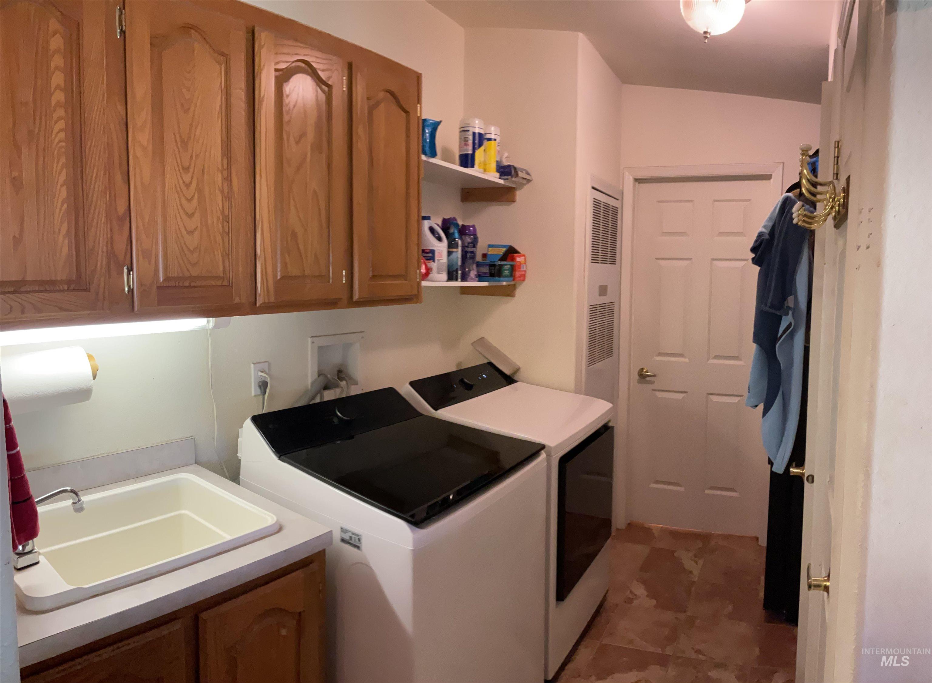 10749 Upper Fords Creek Road Orofino, ID 83544 - Photo 32 of 45 Laundry room with washing machine and dryer, cabinet space, and a heating unit