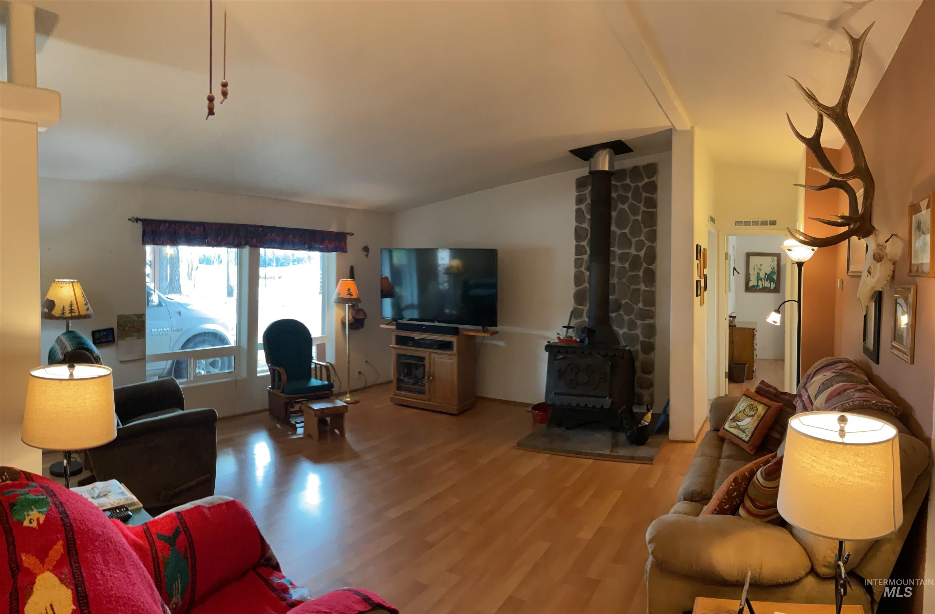 10749 Upper Fords Creek Road Orofino, ID 83544 - Photo 34 of 45 Living room with vaulted ceiling, light wood-style floors, and a wood stove