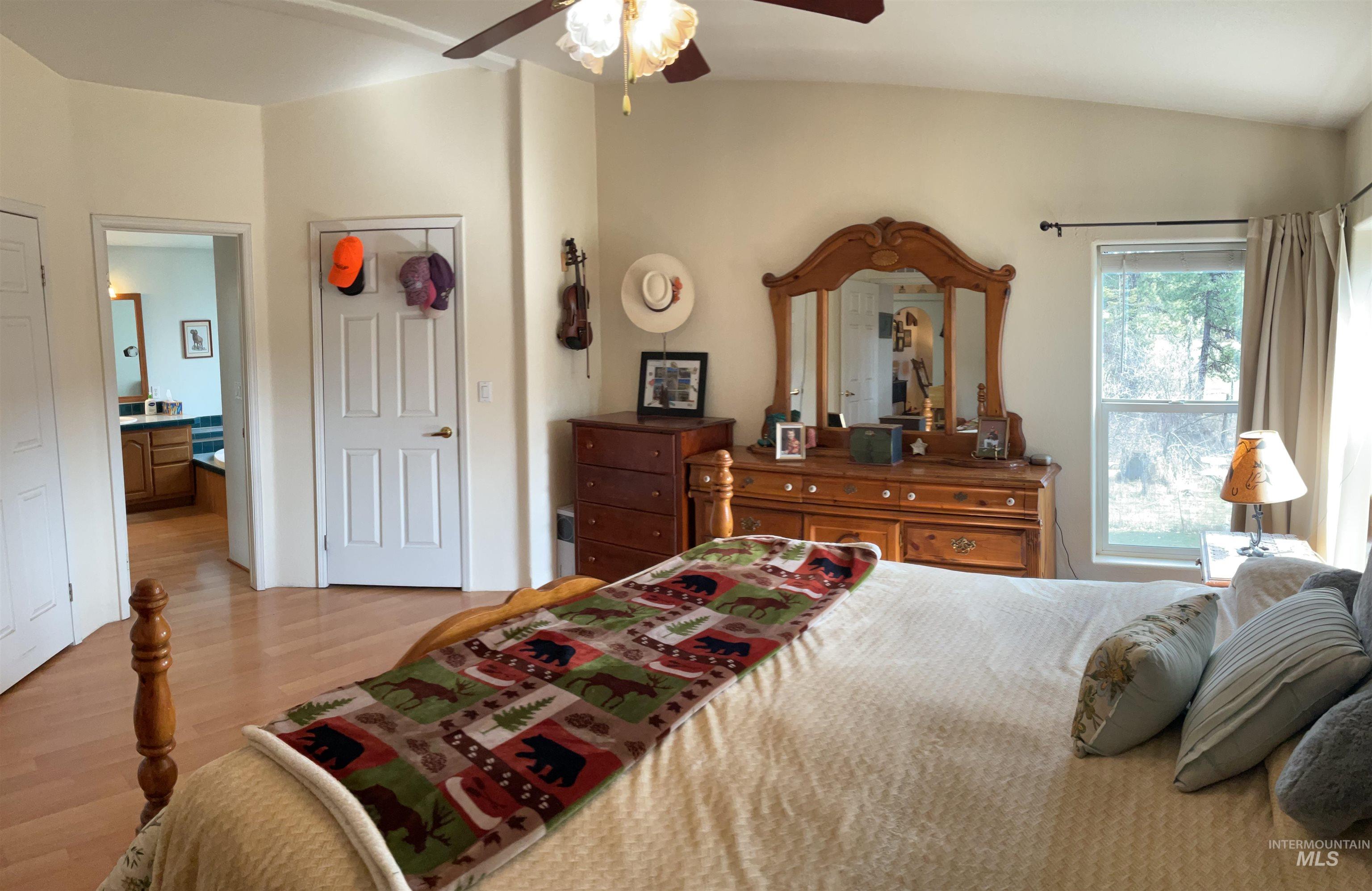 10749 Upper Fords Creek Road Orofino, ID 83544 - Photo 39 of 45 Bedroom with light wood-type flooring, ensuite bathroom, and a ceiling fan