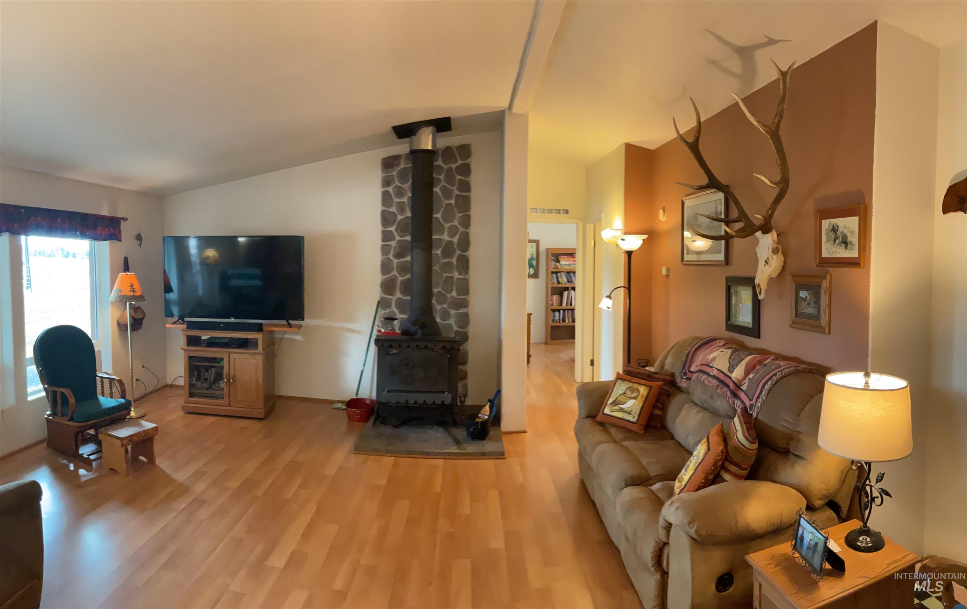 10749 Upper Fords Creek Road Orofino, ID 83544 - Photo 41 of 45 Living area with lofted ceiling, light wood-style flooring, and a wood stove