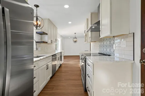 a kitchen with stainless steel appliances granite countertop a sink and a refrigerator