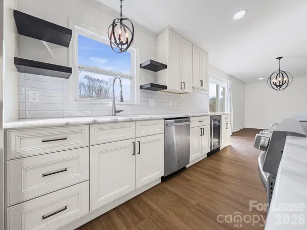 a kitchen with stainless steel appliances granite countertop a sink a stove cabinets and wooden floor