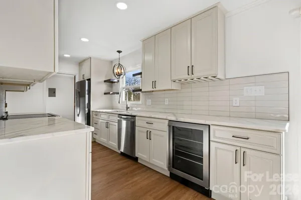 a kitchen with stainless steel appliances granite countertop a sink and white cabinets