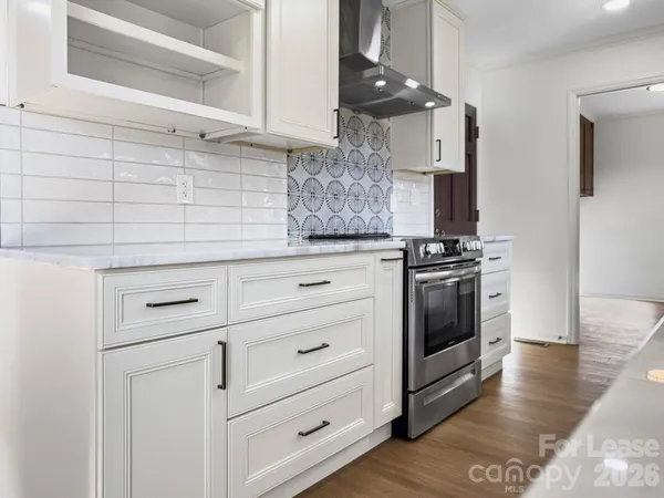 a kitchen with white cabinets and appliances