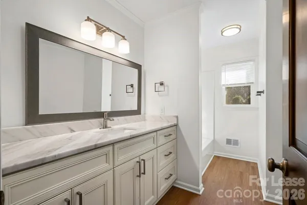 a bathroom with a granite countertop double vanity sink and a mirror