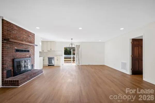 a view of empty room with wooden floor and fireplace