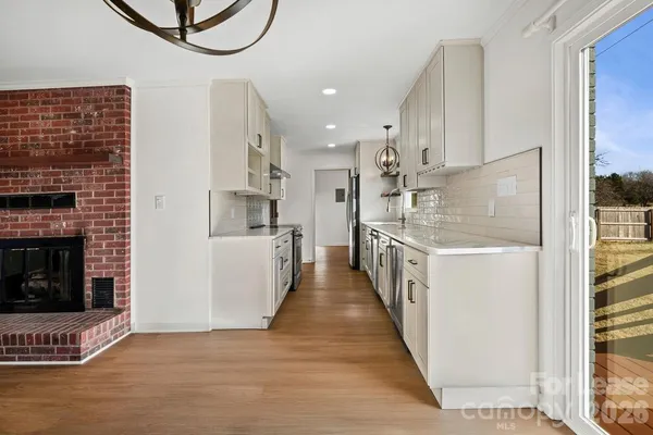 a kitchen with stainless steel appliances granite countertop a refrigerator a stove and a wooden floors