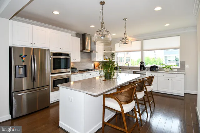 a kitchen with white cabinets a sink and appliances