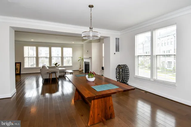 a living room with dining table wooden floor and a fireplace