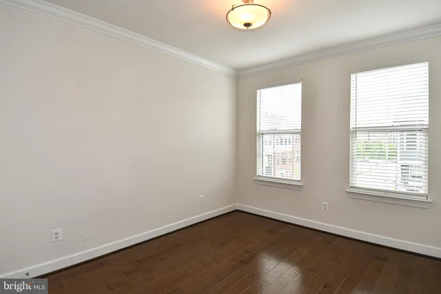a spacious bedroom with a bed and wooden floor
