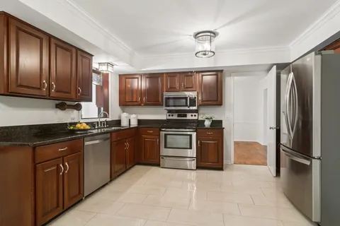 a kitchen with stainless steel appliances granite countertop a stove refrigerator and cabinets