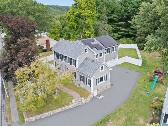 an aerial view of a house with a big yard and large trees