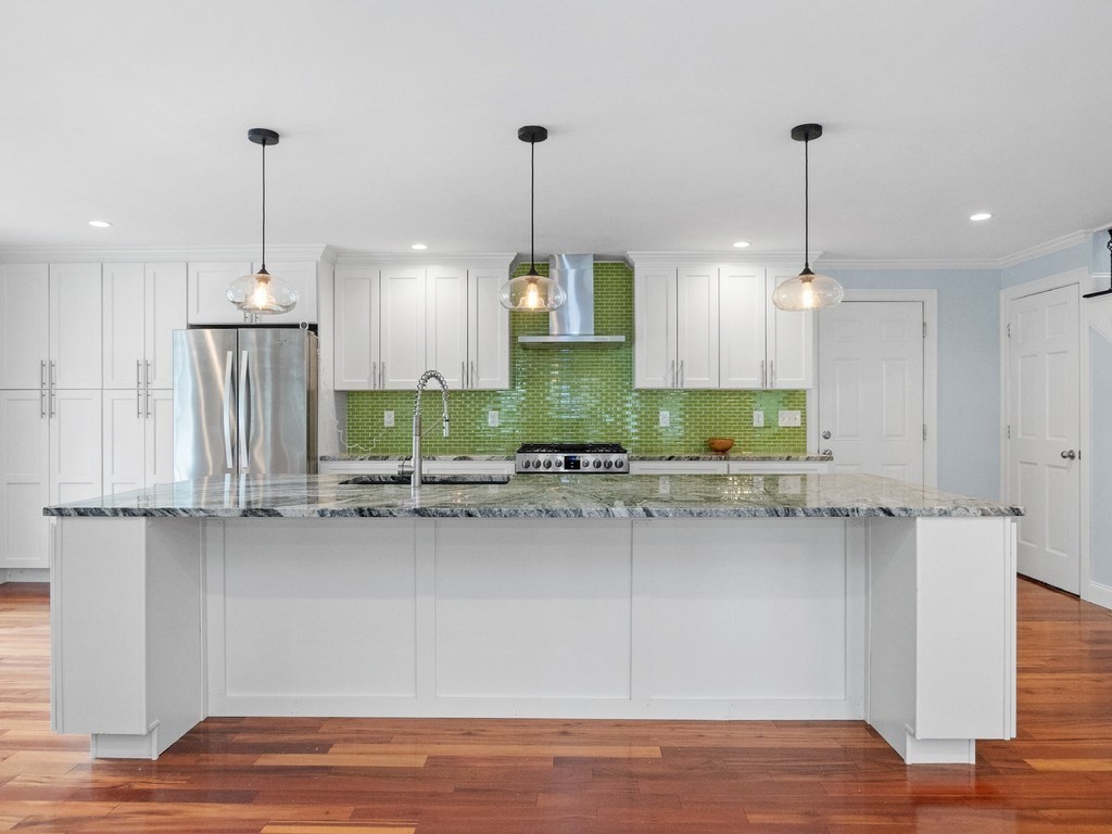 1767 Trapelo Road Waltham, MA 02451 - Photo 6 of 39 a kitchen with kitchen island granite countertop a stove a sink a center island a refrigerator and a wooden floor