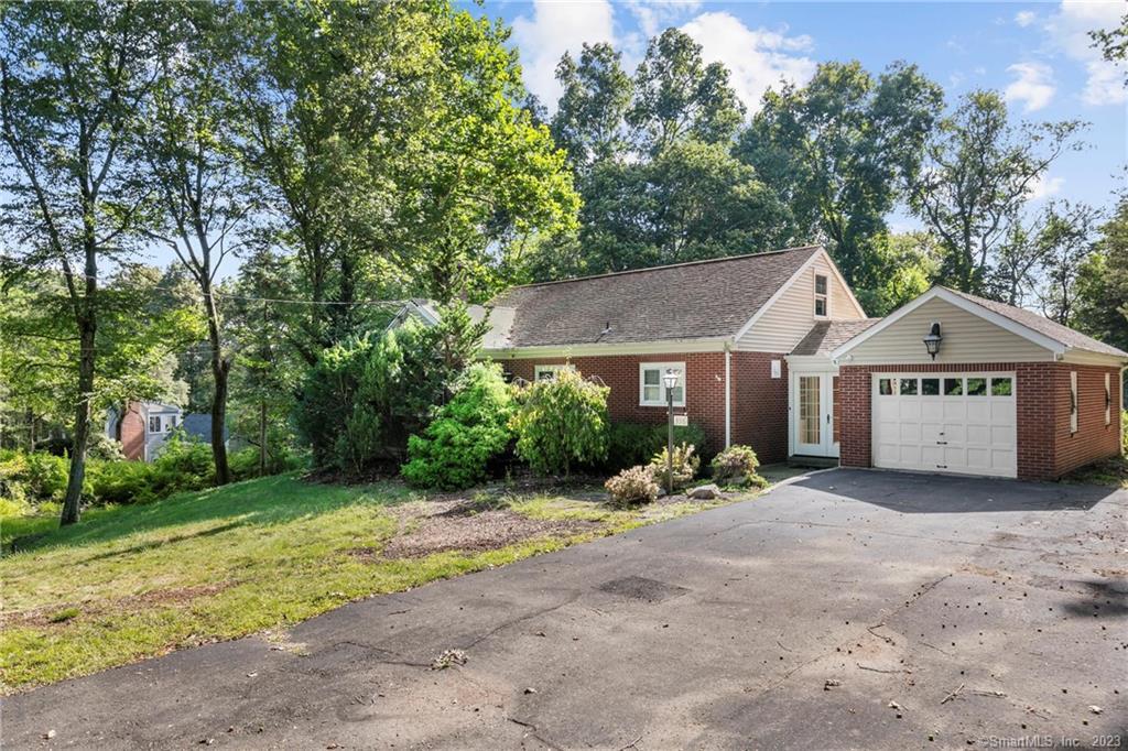 a view of a house with a yard and large trees